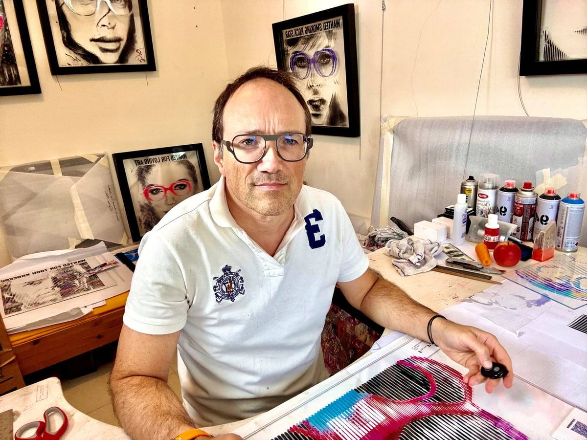 Fabian PhiL at work in his Dubai studio, surrounded by spray cans and framed portraits.