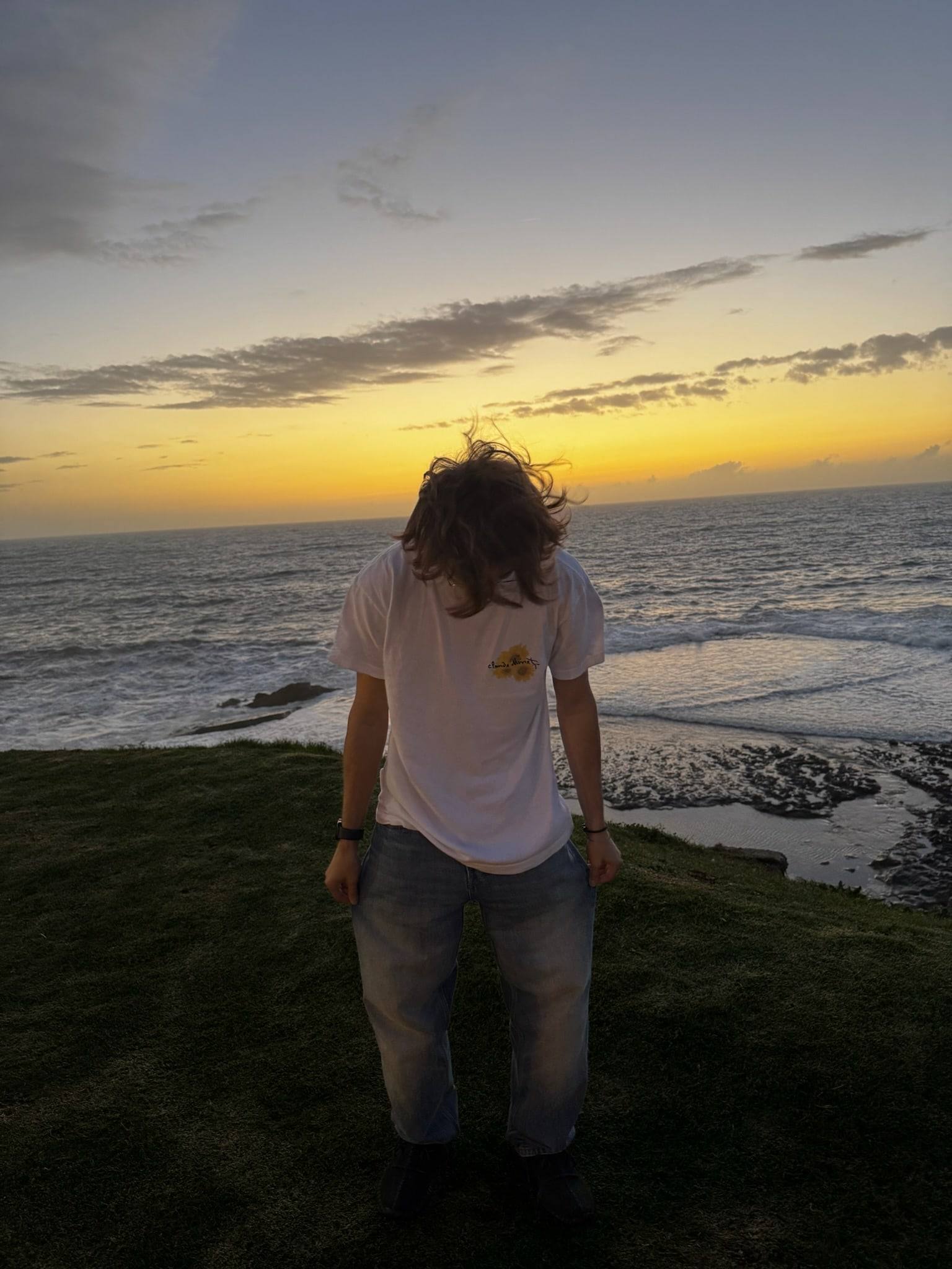 Sinclair, hair blowing, facing the Atlantic at sunset in Rabat.